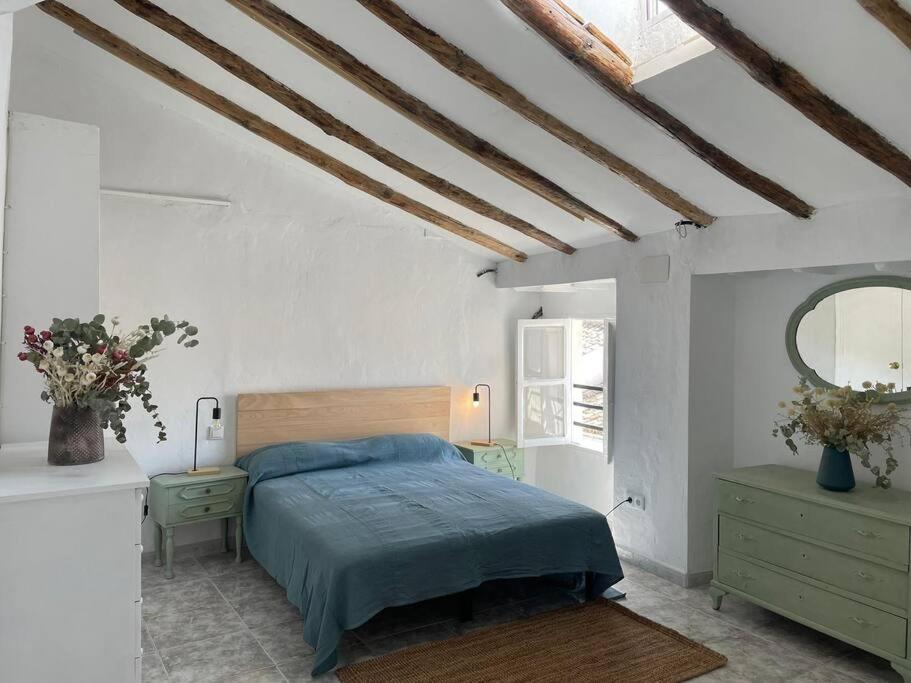 ein weißes Schlafzimmer mit einem Bett und einem Spiegel in der Unterkunft La casita de la fuente in Cazorla