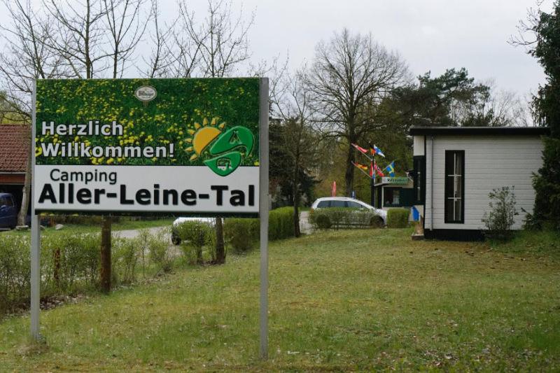 una señal en un campo con una casa y un edificio en Camping Aller Leine Tal en Engehausen