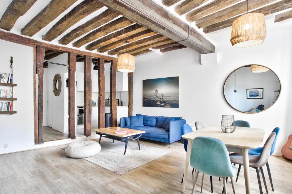un salon avec un canapé bleu et une table dans l'établissement Charme et Chic du Marais, à Paris