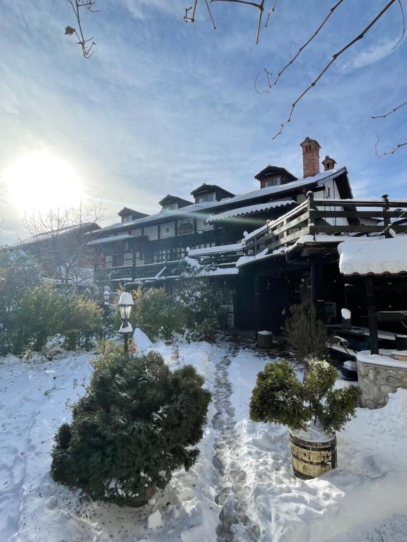 a house in the snow with trees in front of it at Chalet Mila - Total Chalets - Fully Catered in Bansko