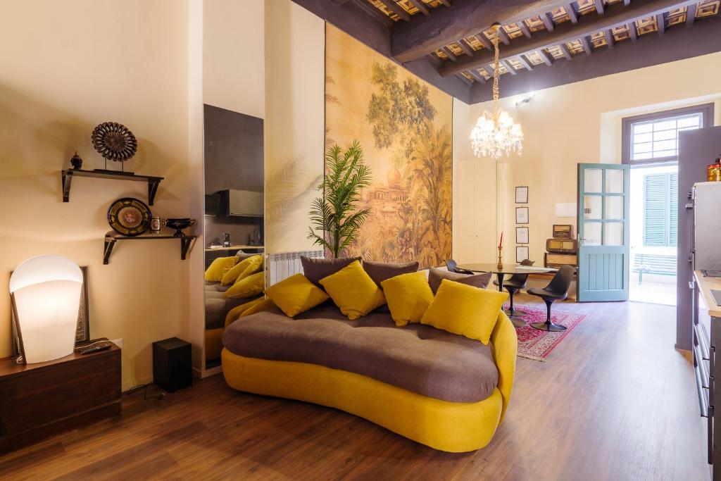 un soggiorno con divano e cuscini gialli di “Lo Scrigno” della Corte di Corso Cavour a Foligno