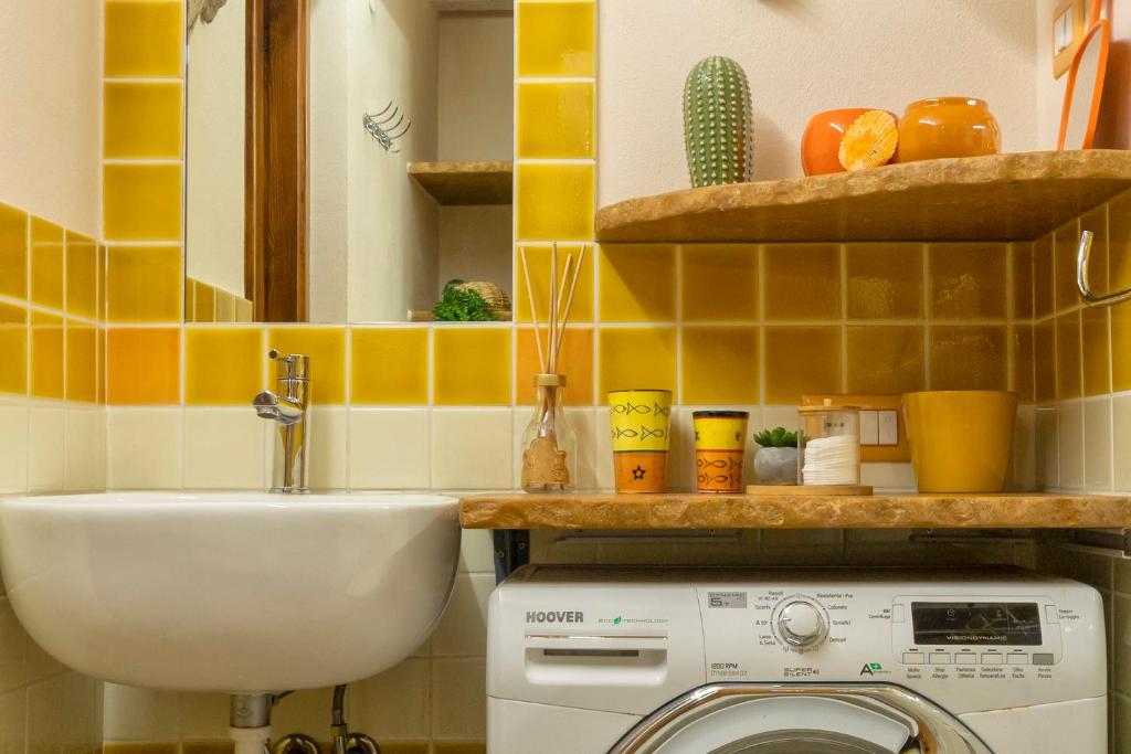 łazienka z pralką i umywalką w obiekcie La Casa di Zaira w mieście Alghero