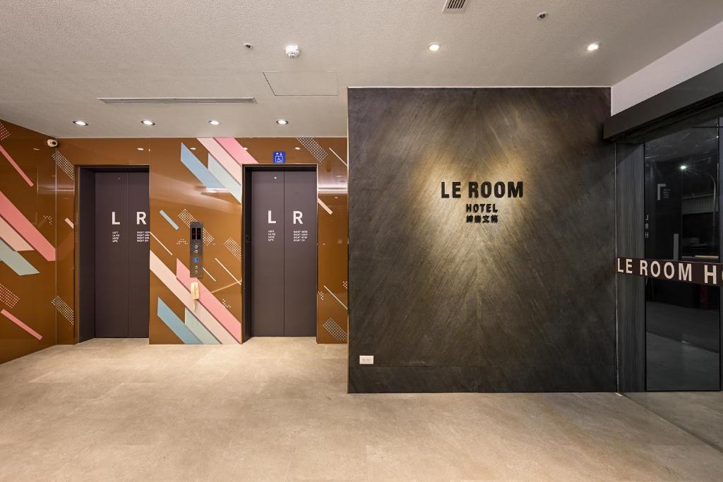 a lobby with two elevators and a door with the words le room with me at 綺樂文旅 桃園館 Le Room Hotel Taoyuan in Taoyuan