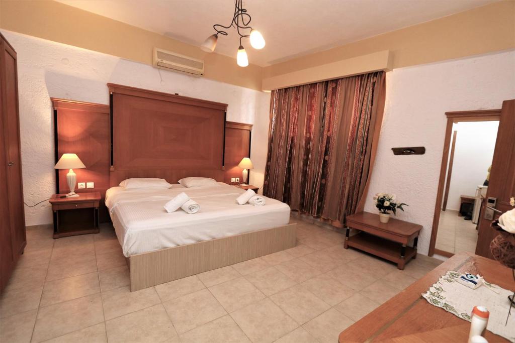um quarto de hotel com uma cama grande e duas mesas em Tris Ekklisies Beachfront Apartment - Ammos em Paránimfoi