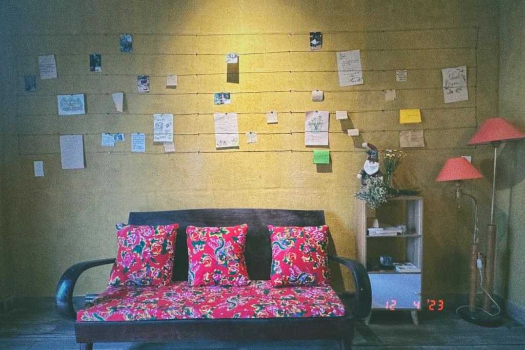 ein Sofa mit Kissen in einem Zimmer mit einer Wand mit Anmerkungen in der Unterkunft Maison de Hill Home in Dồng Văn