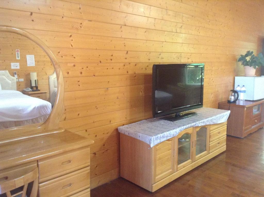 a room with a tv on a wooden wall at Bunbury Fruit Ranch B&amp;B in Ren&#39;ai