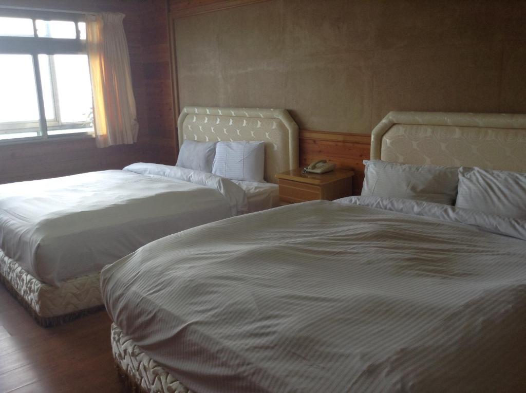 a hotel room with two beds and a window at Bunbury Fruit Ranch B&amp;B in Ren&#39;ai