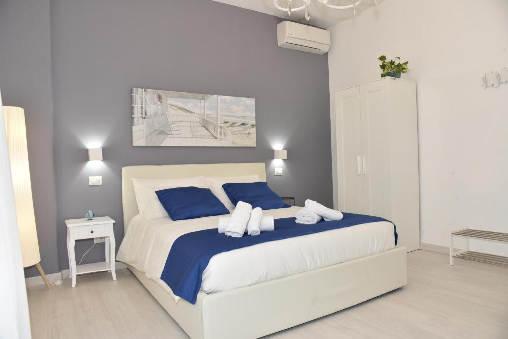a bedroom with a large bed with blue pillows at NathanaEle House Via Tuscolana in Rome