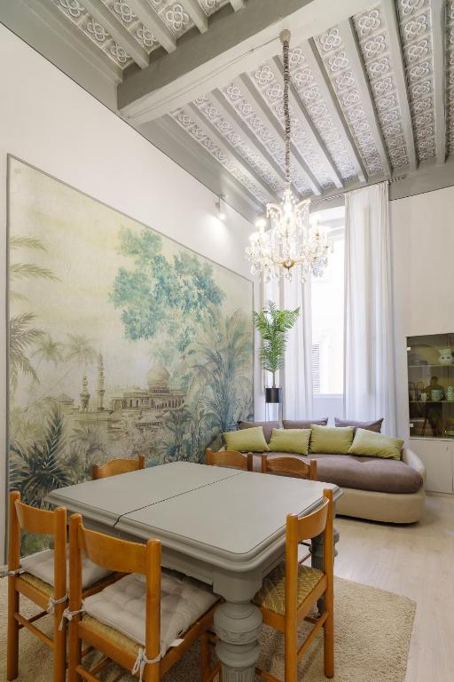 a living room with a table and chairs and a chandelier at Il Salotto in Foligno