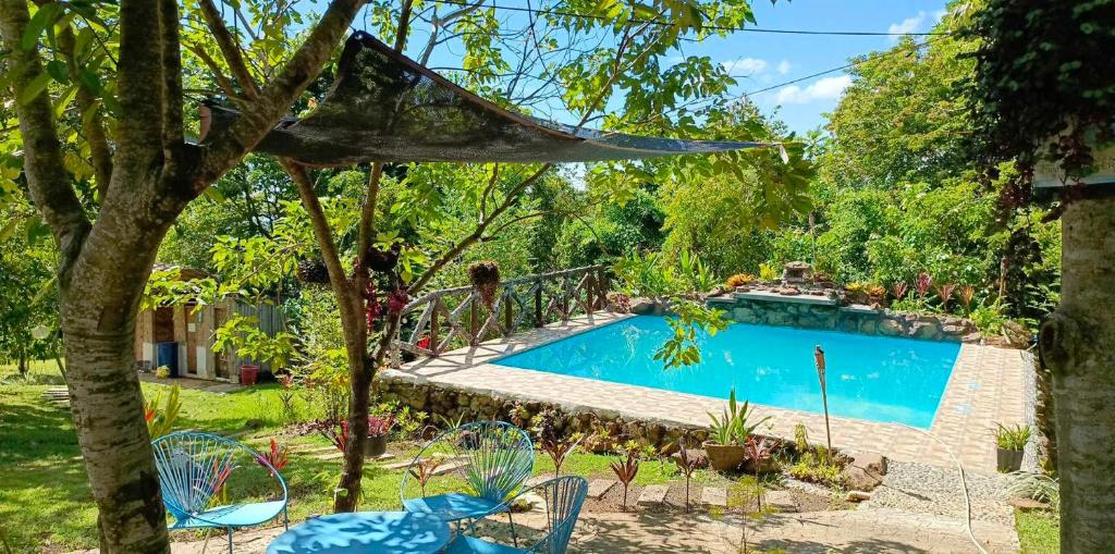 una piscina in un cortile con tavoli e sedie di FrancoEly's A Family Camp a Daliao