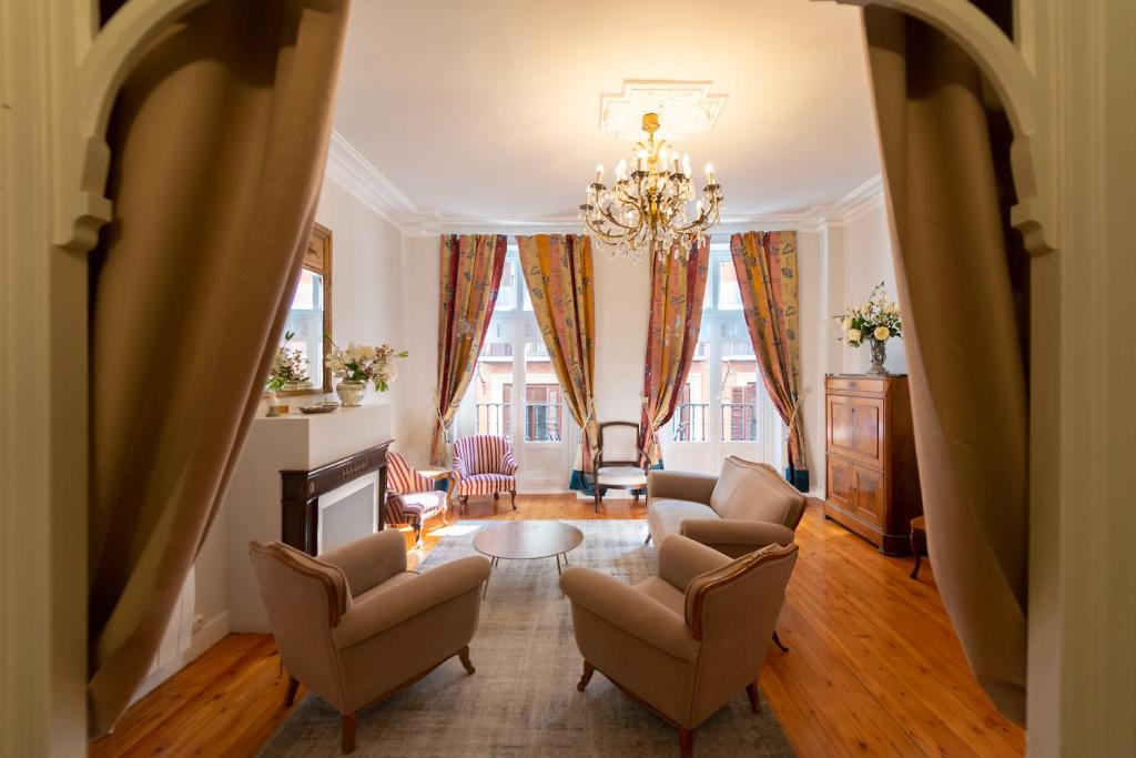 uma sala de estar com cadeiras e um lustre em Heart of Pamplona Palace em Pamplona