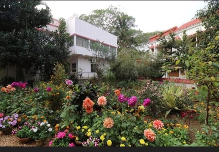 um jardim de flores em frente a um edifício em Rajlaxmi Resort - Pure Veg em Bolpur