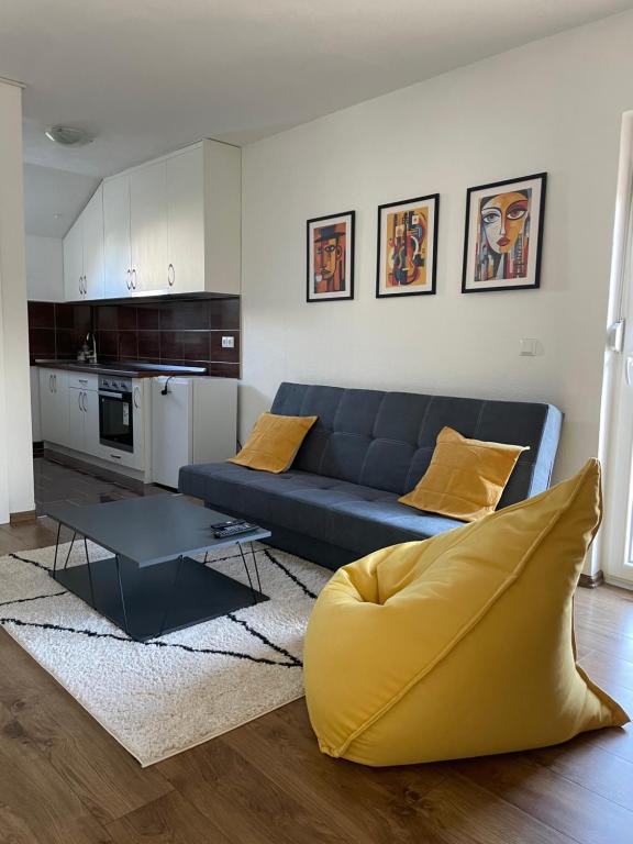 un soggiorno con divano blu e una cucina di Apartman Dolly Bell a Kotor-Varoš