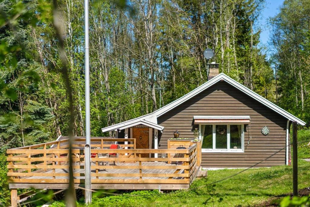 a small cabin with a porch in the woods at Beautiful Cabin by Mjøsa. in Stange