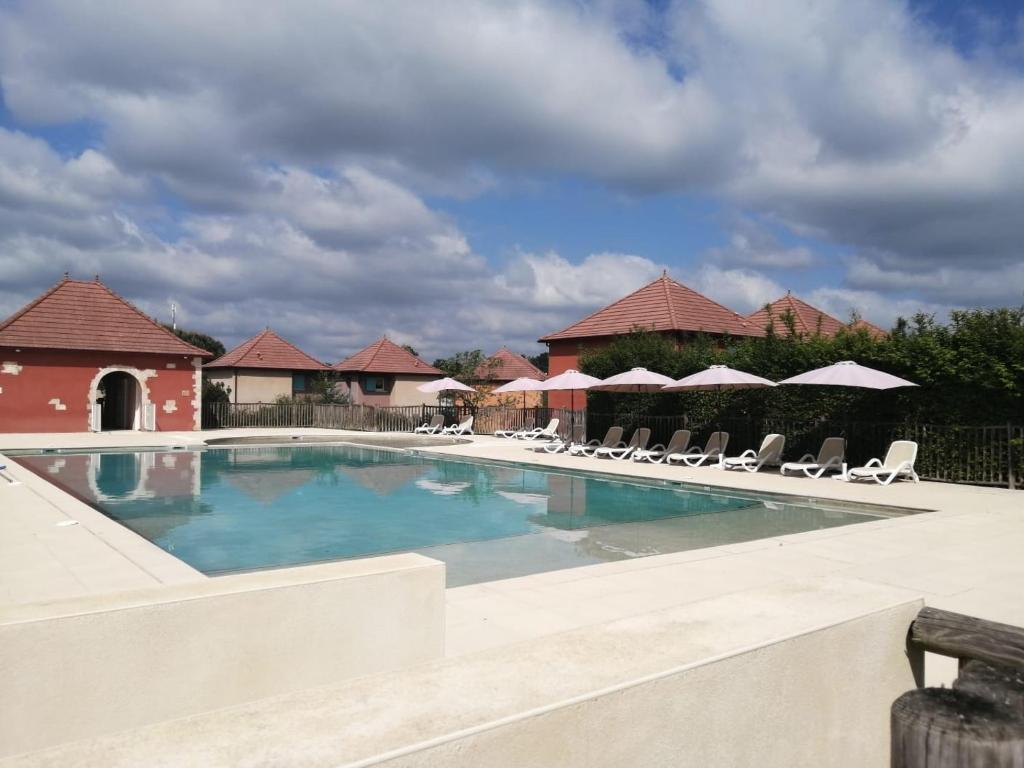a large swimming pool with chairs and umbrellas at Résidence Claire Rive in Prayssac