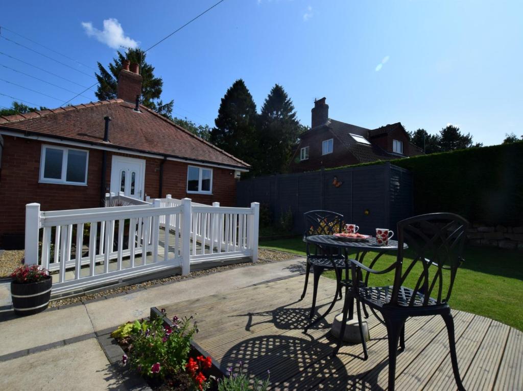 a patio with a table and chairs and a white fence at 1 Bed in Harrogate 66981 in Knaresborough