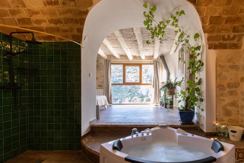 baño con bañera y suelo de baldosa verde en Casa rural Vall de Gallinera con Chimenea, piscina y jacuzzi DIANIA, en Patró