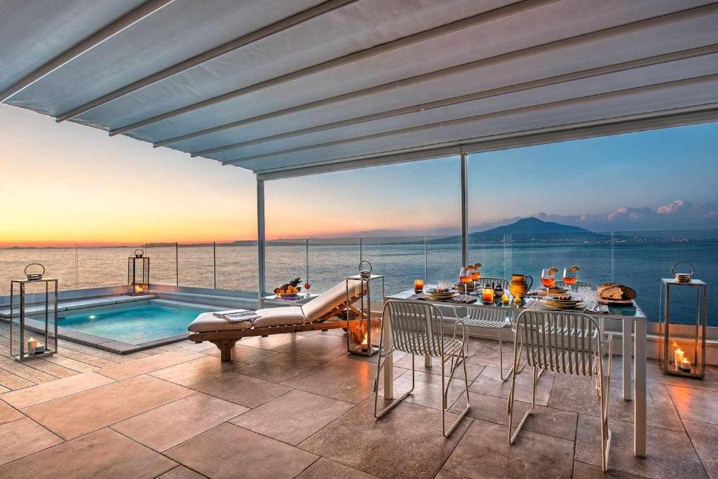 a house with a pool and a table and chairs at GOCCE VILLAS - Villa Degli Dei Waterfront Villa in Vico Equense