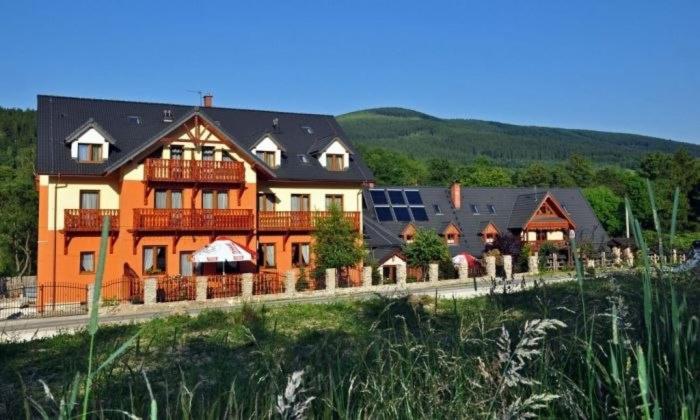 a large orange house with aasteryasteryasteryasteryasteryasteryasteryasteryasteryastery at Hotelik Orański in Stronie Śląskie