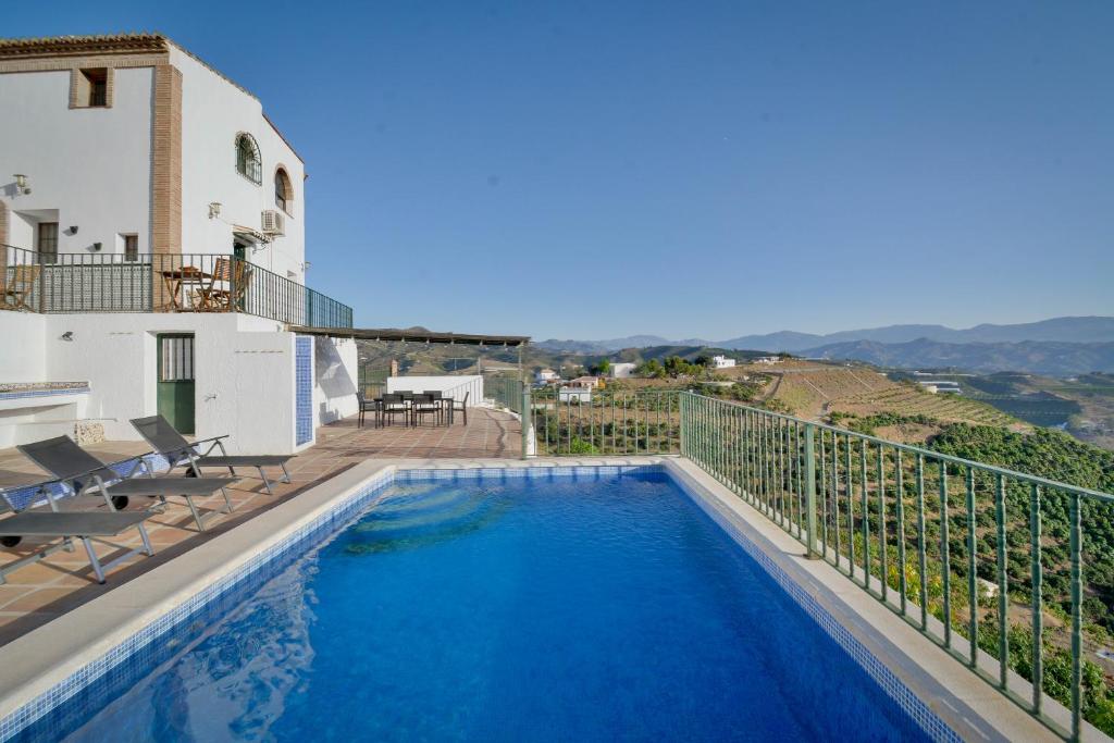 Cette villa dispose d'une piscine et d'un balcon. dans l'établissement Villa Portillo, à Iznate