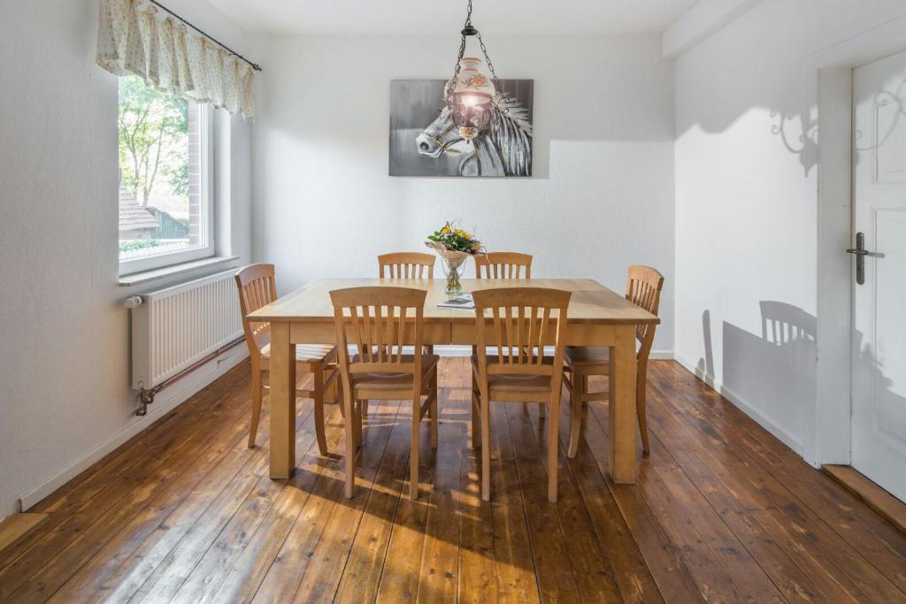 a dining room with a wooden table and chairs at Landidyll in Uchte