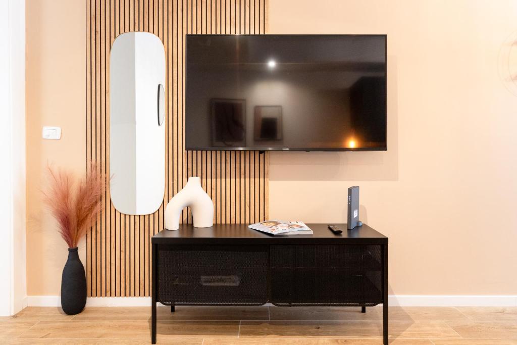 a black dresser with a television on a wall at THE BASEMENT in Milan