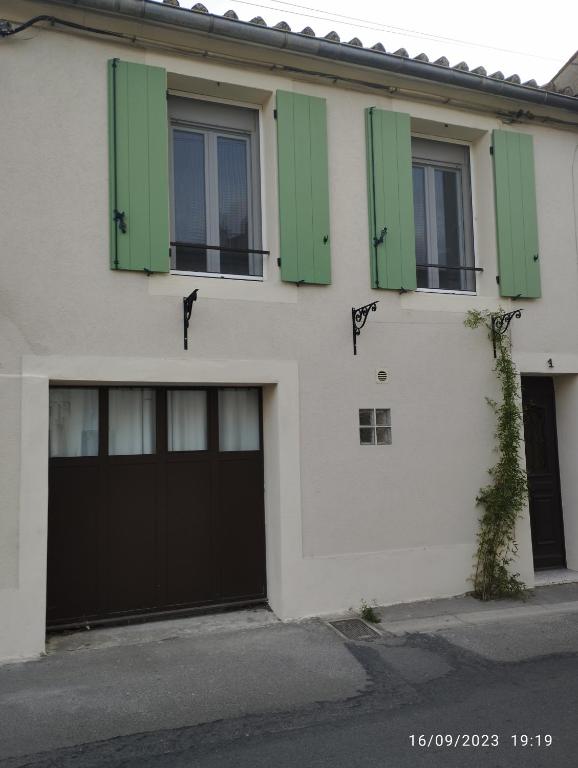 une maison blanche avec volets verts dans l'établissement Chez Marius, à Aigues-Mortes