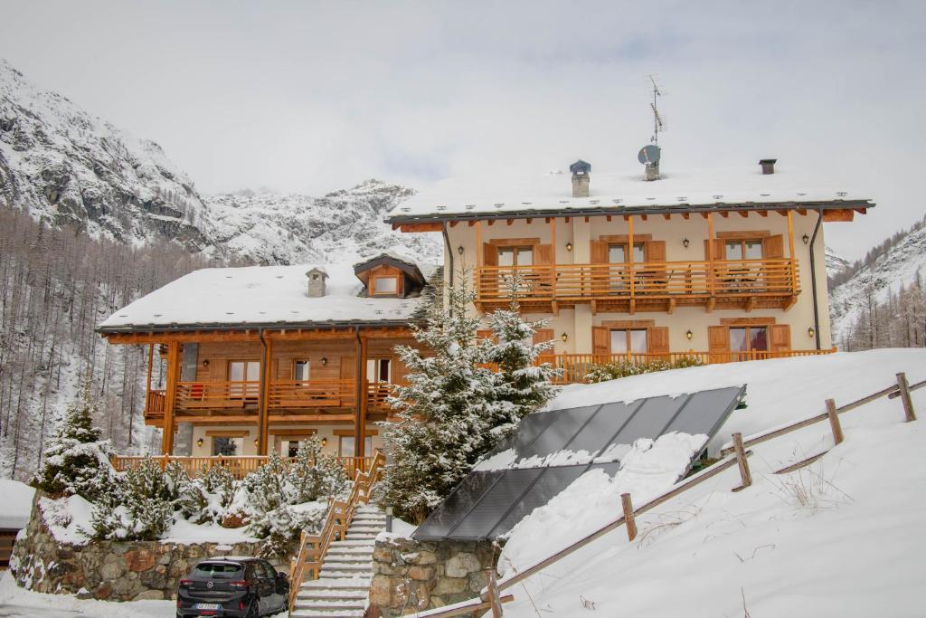 a large wooden house with a snow covered roof at Ellex Eco Hotel in Gressoney-la-Trinité