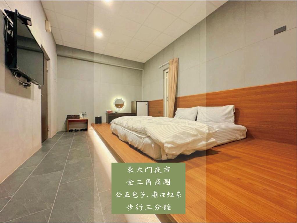 1 dormitorio con 1 cama y TV de pantalla plana en 鼓道民宿-步行五分鐘-東大門夜市-及夜市收費停車場 en Hualien