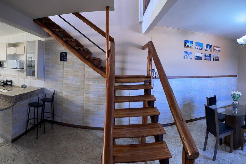 uma escada num quarto com uma cozinha e uma mesa em Residencial Vista da Serra em Diamantina