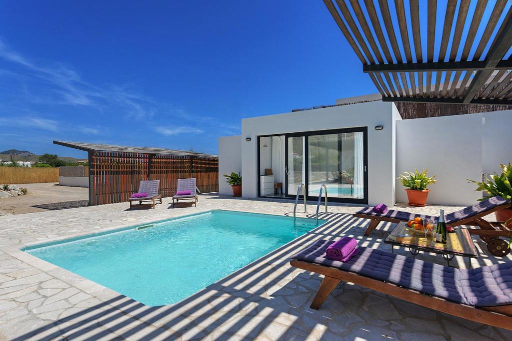 een zwembad met 2 ligstoelen en een huis bij Villa Marcelino in Port de Pollença