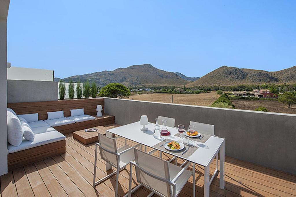 ein Balkon mit Tisch und Stühlen und Bergen in der Unterkunft Penthouse Dalias in Port de Pollença