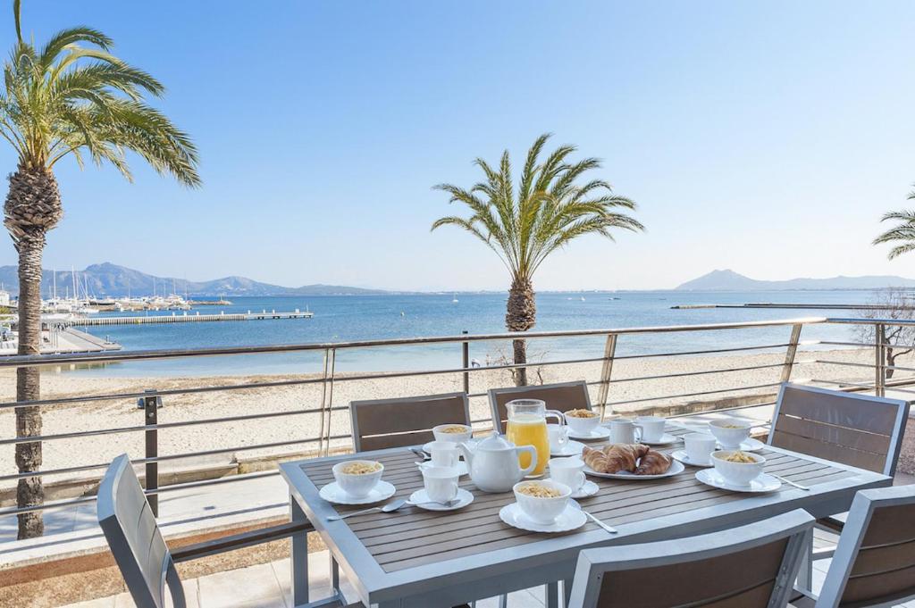 een tafel met eten en uitzicht op de oceaan bij Apartment VistaMar I in Port de Pollença