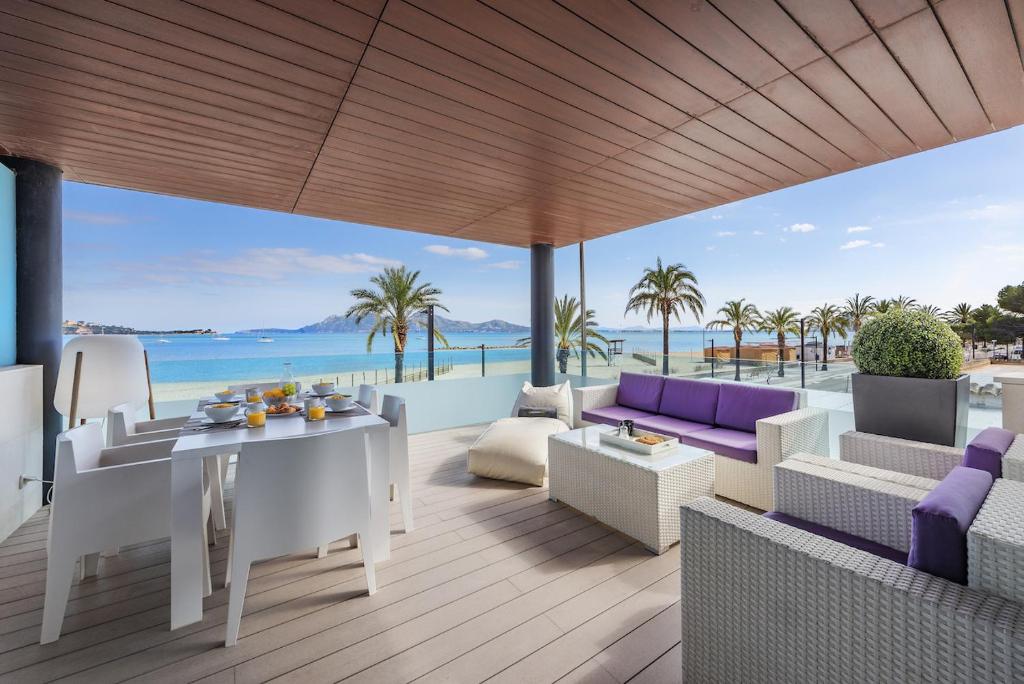 a patio with a table and chairs and the ocean at Londres Derecha in Port de Pollensa