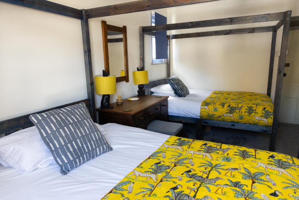 a bedroom with two beds and a desk with two lamps at CloudZen in Kent