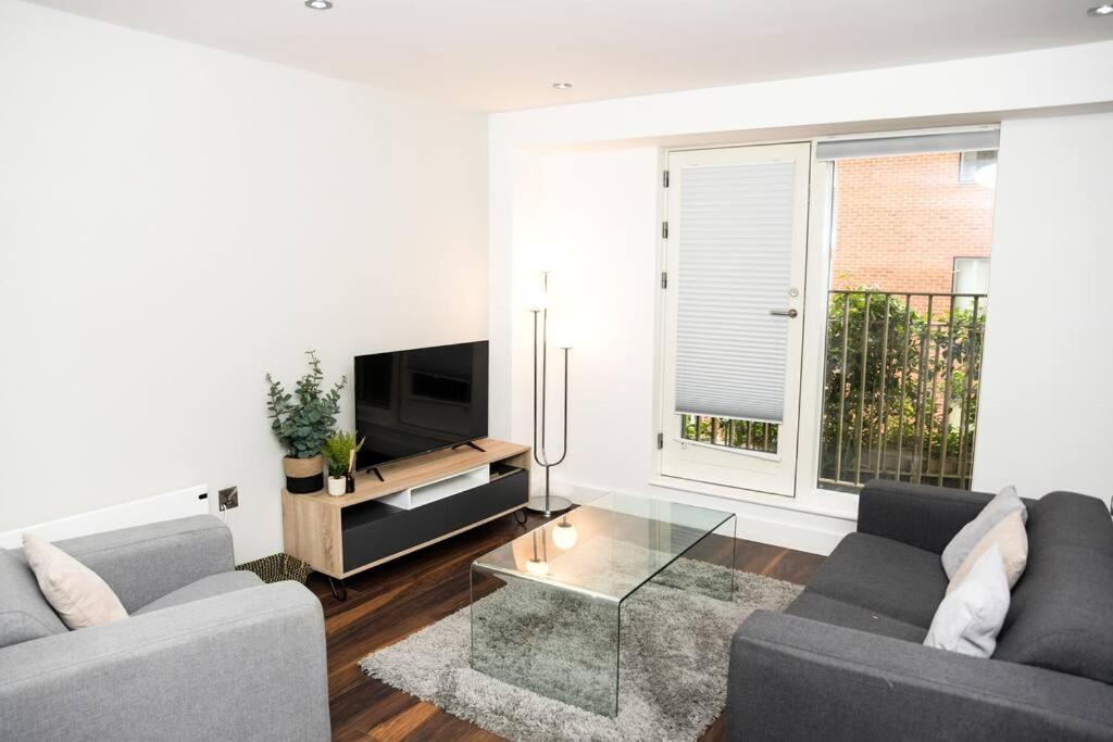 a living room with two couches and a television at OnPoint - Spacious 2 Bedroom Apt, City Centre! in Manchester