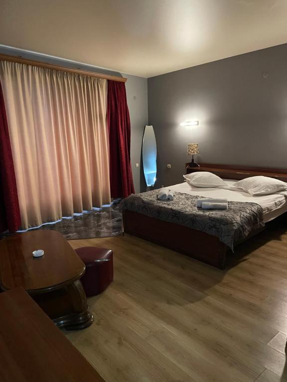 a bedroom with a bed and a table and a chair at Hotel ERA in Tbilisi City