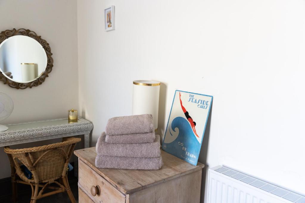 a pile of towels on a wooden box in a bathroom at CloudZen in Kent