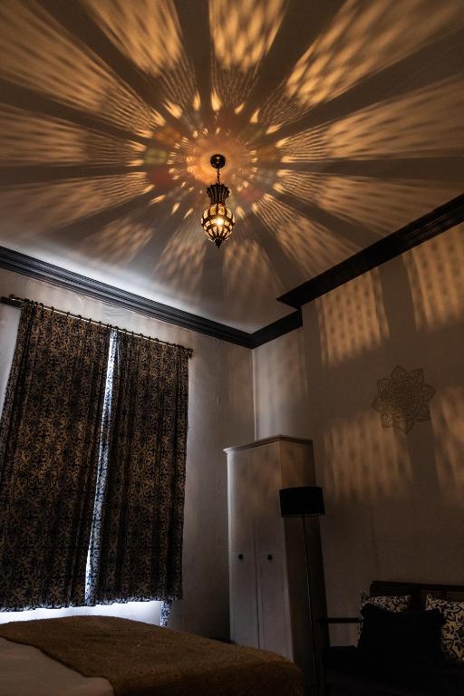 a bedroom with a ceiling with a chandelier at CloudZen in Kent