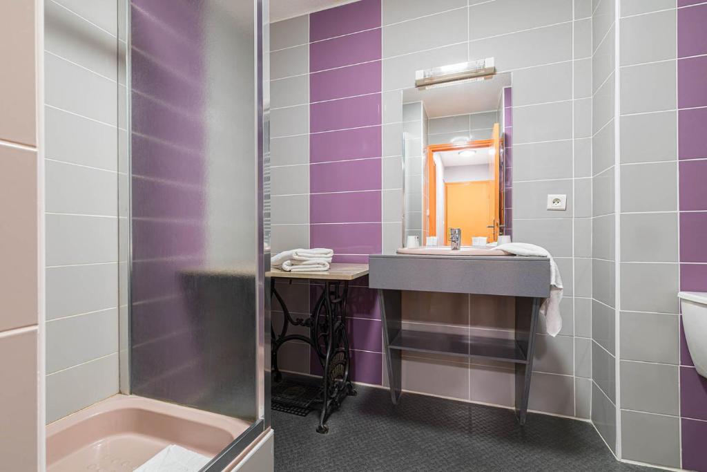 a bathroom with a sink and a mirror at Hotel L&#39;Abri in Le Puy-en-Velay