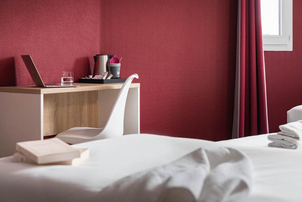 a bedroom with red walls and a white bed at Hotel L&#39;Abri in Le Puy-en-Velay