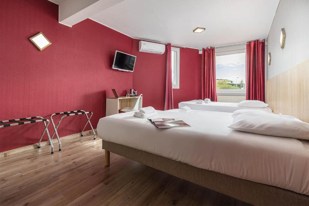 a bedroom with red walls and a bed with a tub at Hotel L&#39;Abri in Le Puy-en-Velay