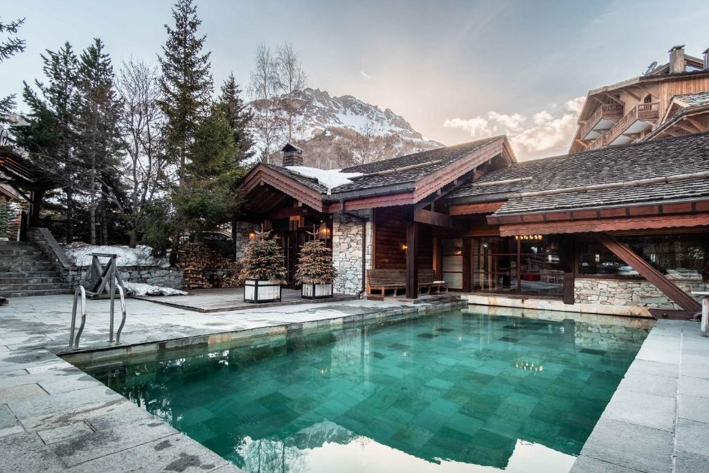 a swimming pool in front of a house at Hôtel LE BLIZZARD in Val-d'Isère