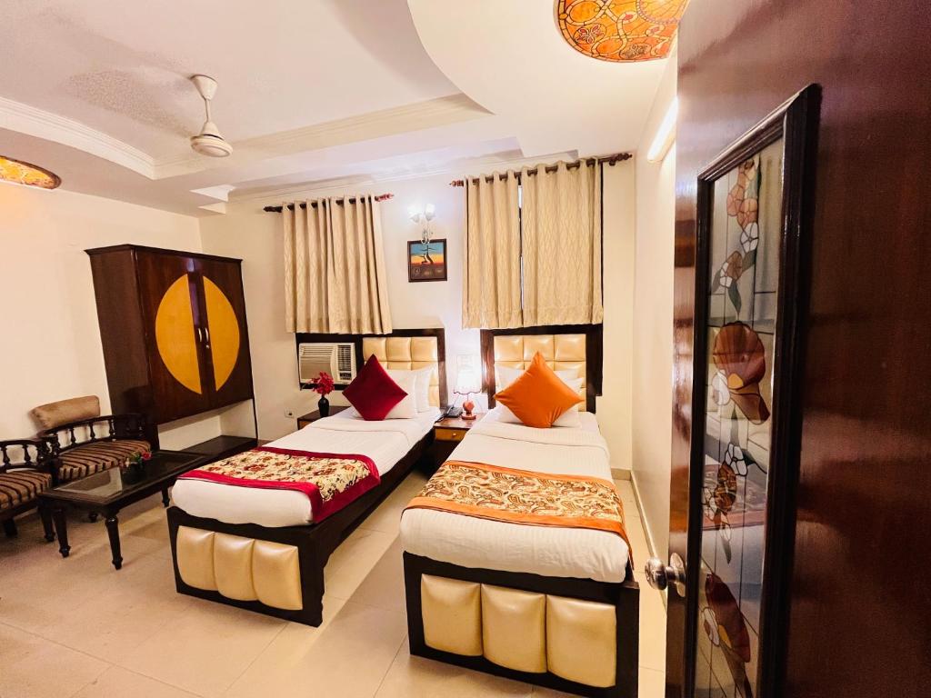 pokój hotelowy z 2 łóżkami i kanapą w obiekcie Hotel Paras - Karol Bagh Delhi w Nowym Delhi