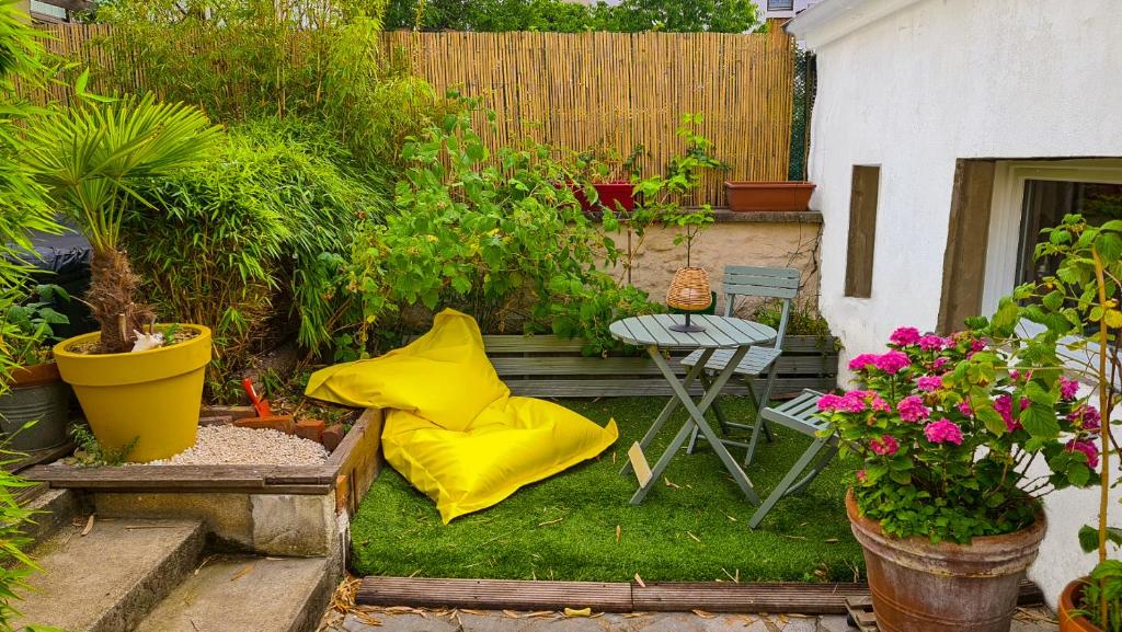- un jardin avec un oreiller jaune assis sur l'herbe dans l'établissement Le studio dans le jardin., à Rosny-sous-Bois