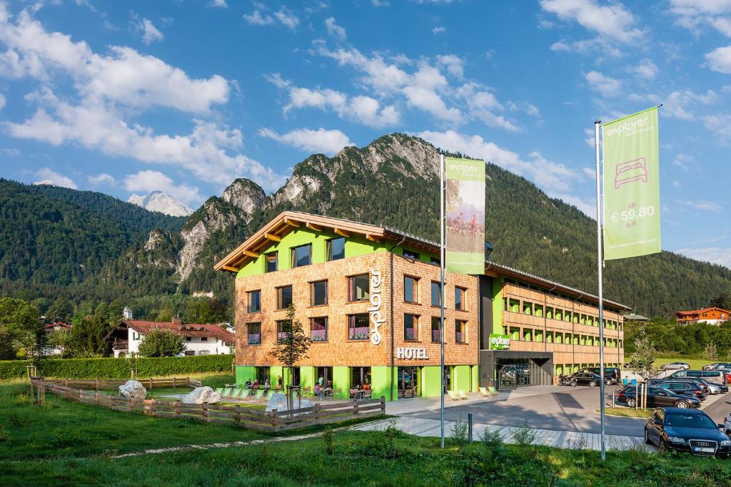 a building with a mountain in the background at Explorer Hotel Berchtesgaden in Schönau am Königssee