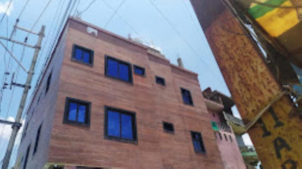 un edificio in mattoni marroni con finestre blu di Hotel Sai Prabha, Bhind a Bhind