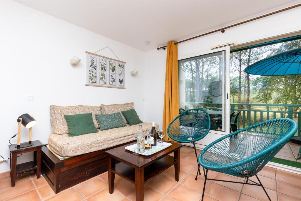 sala de estar con sofá y 2 sillas en Blue Pinsolle - Appt avec piscine partagée, en Soustons