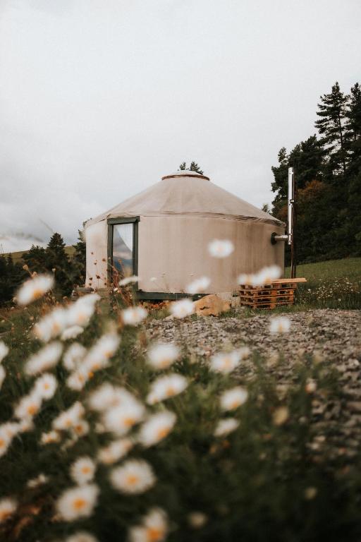 a large dome tent in a field with flowers at Jurta I Sauna z widokiem na Tatry in Knurów