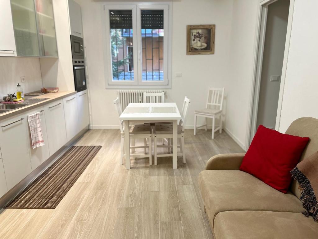 eine Küche und ein Wohnzimmer mit einem Sofa und einem Tisch in der Unterkunft bandbinbologna in Bologna
